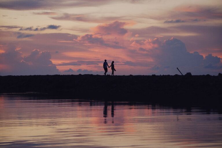 Couple silhouette main dans la main au bord du lac - avis Jacquie et Michel
